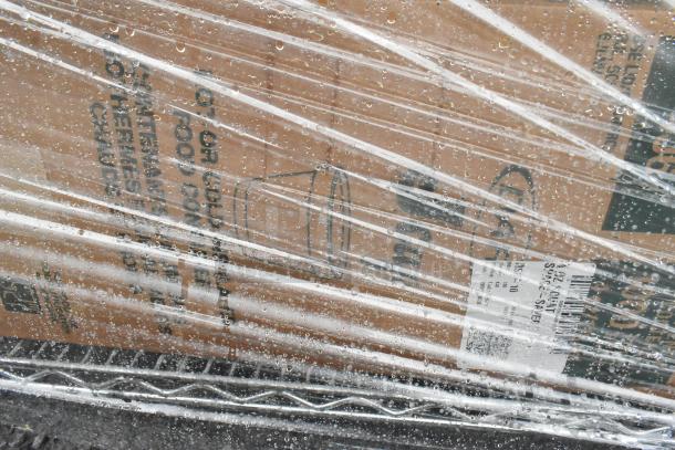Chrome finish 5-tier wire shelving unit wrapped in plastic, includes YL2512 containers and baskets. Buyer must dismantle.
