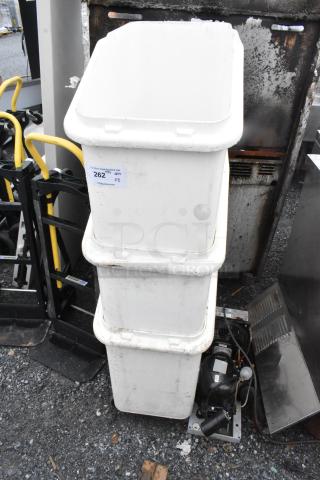 Three white poly ingredient bins on commercial casters, stacked vertically, showing signs of wear, labeled "262 QTY x3".