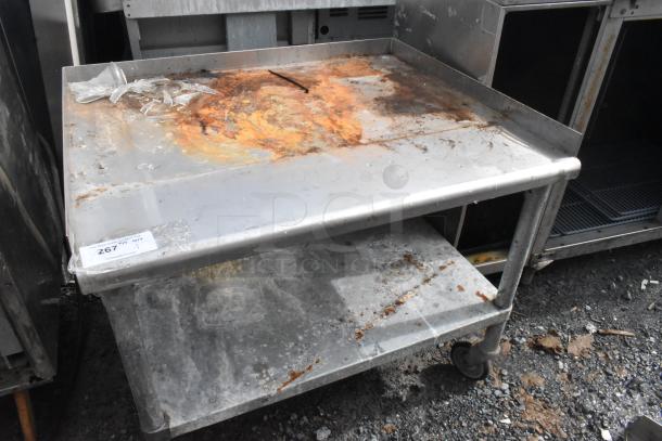 Stainless steel equipment stand with metal under shelf, commercial casters, rusted top. Label reads "267 QTY 1".