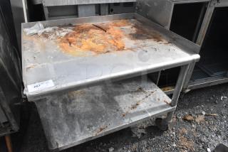 Stainless steel equipment stand with metal under shelf, commercial casters, rusted top. Label reads "267 QTY 1".