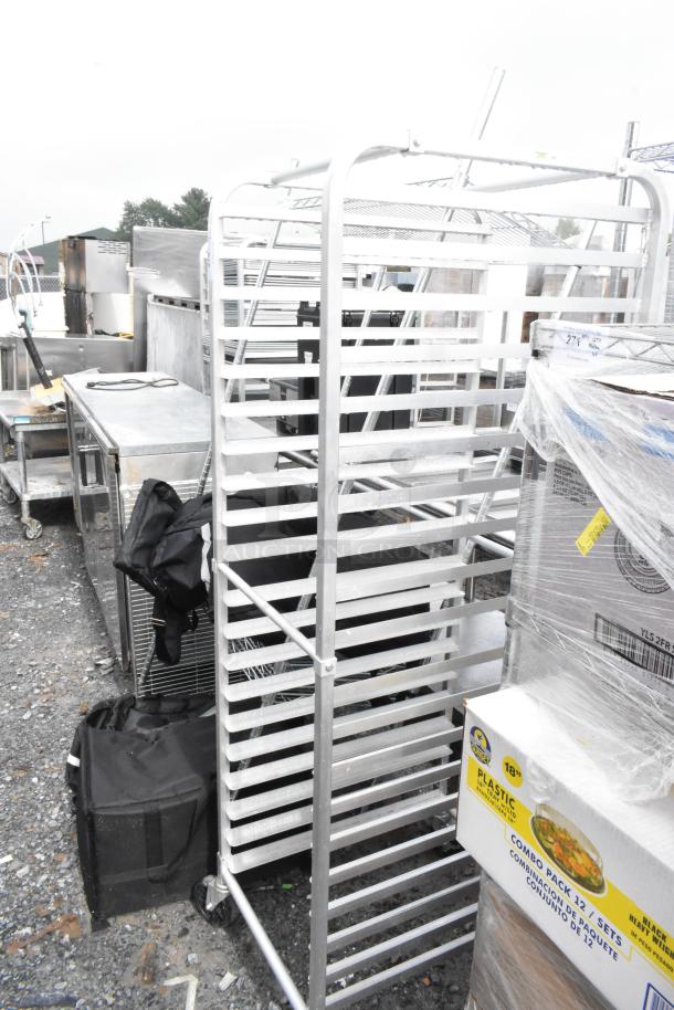 Metal pan transport rack with multiple shelves on commercial casters, used condition. Ideal for kitchen or bakery use.
