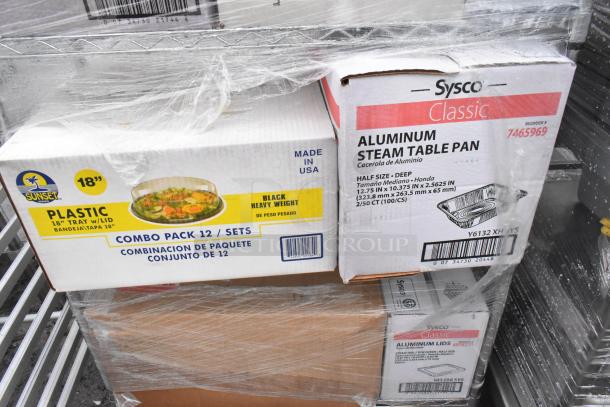 Chrome finish wire shelving unit with various boxed contents, including Sysco aluminum steam pans and Sunset plastic trays. Commercial casters included.