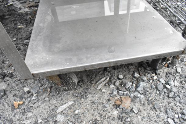 Metal 3 tier cart with rusted wheels, includes commercial can opener. Signs of wear and surface stains.