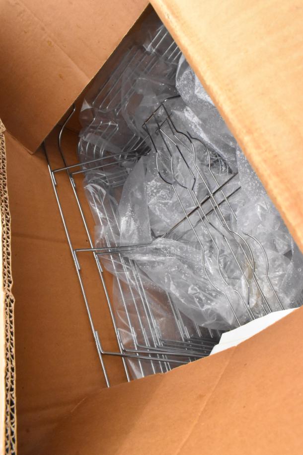 Cardboard box containing disassembled components of a gray poly 2-tier cart, commercial casters visible, appears unused.