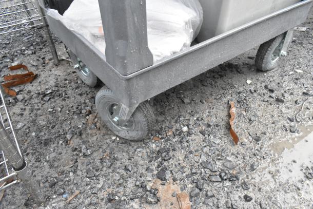 Gray poly 2-tier cart with commercial casters, showing durable wheels and sturdy construction. Used condition.