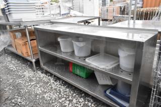 Stainless steel table with two metal under shelves, slightly used; features perforated shelves for drainage and storage.
