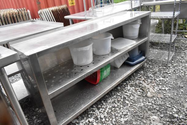 Stainless steel table with two metal under shelves, used condition, suitable for commercial use.