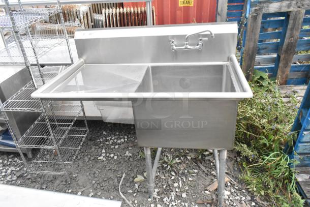 Stainless steel single bay sink with left side drain board, faucet, and handles in excellent condition.