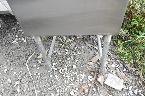 Stainless steel single bay sink with left side drain board, faucet, and handles. Mounted on sturdy legs, good condition.