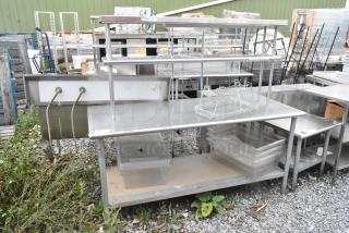 Stainless steel table with metal under shelf and 2-tier over shelf. Used condition, ideal for commercial kitchen storage.