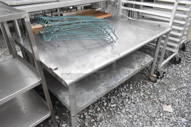 Stainless steel equipment stand with metal under shelf on commercial casters, showing signs of use. Tag reads "2857".