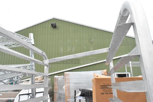 2 metal pan transport racks on commercial casters, outdoor setting, metallic finish, suitable for kitchen or storage use.