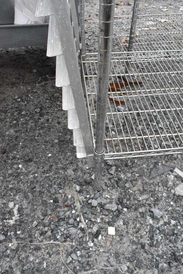 Chrome finish 4 tier wire shelving unit, sturdy metal construction, marked measurement scale on posts, outdoor setting.