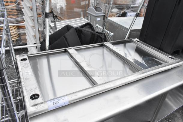 Stainless steel tabletop with drainage holes and reinforced frame. Good condition, item number 293 visible on tag.