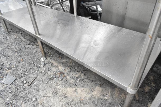 Stainless steel table with under shelf, sturdy build, minor surface wear, ideal for industrial or kitchen use.