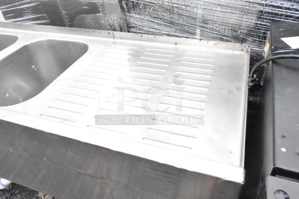 Stainless steel 3 bay back bar sink with dual drain boards, lightly used. Features rust-resistant finish, ideal for commercial use.