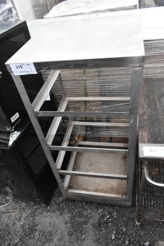 Metal rack on commercial casters, stainless steel, open shelves, visible wear. Auction tag reads "310."