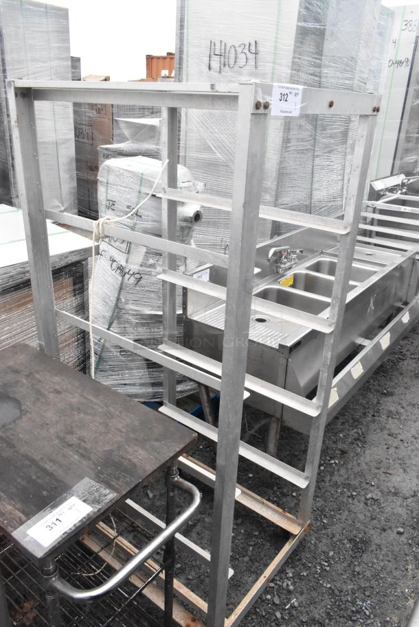 Metal commercial pan transport rack, durable design on commercial casters, exhibits some wear. Label "312".