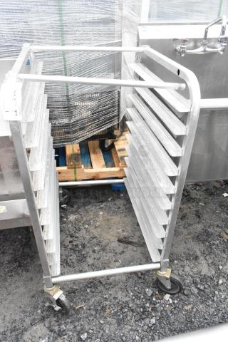 Metal commercial pan transport rack with multiple shelves and sturdy commercial casters, used condition.
