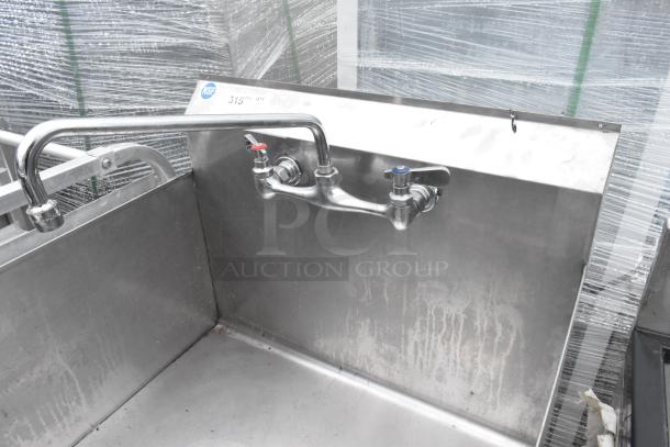 Stainless steel single bay sink with dual-handle faucet, NSF certified, visible minor wear, ideal for commercial use.