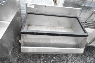 Stainless steel ice bin with speedwell, no legs. Features black rim, visible drain hole. Tag reads "316." Good condition.