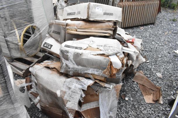 Damaged boxes containing 10 new items including Regency drawer and Steelton shelf kit, labels visible, placed on gravel.