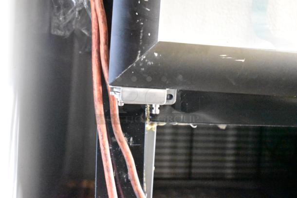 Mainstreet 829GMC49B Reach In Cooler corner showing poly coated racks and minor scratches on black metal exterior.