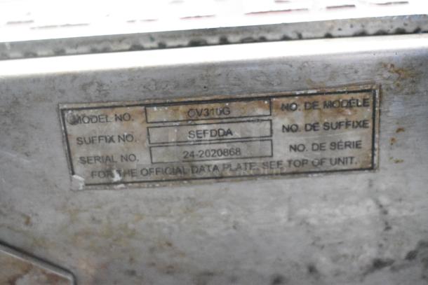 Baxter OV310G stainless steel rotating rack oven label with model and serial numbers, mounted on a dual pan rack.