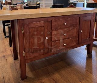 Amish-made wooden storage cabinet with two doors, three drawers, white knobs, and a light wood countertop in excellent condition.