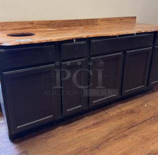 Wooden display/storage cabinet with black finish, countertop, and cutout for trash. Features multiple doors and drawers.