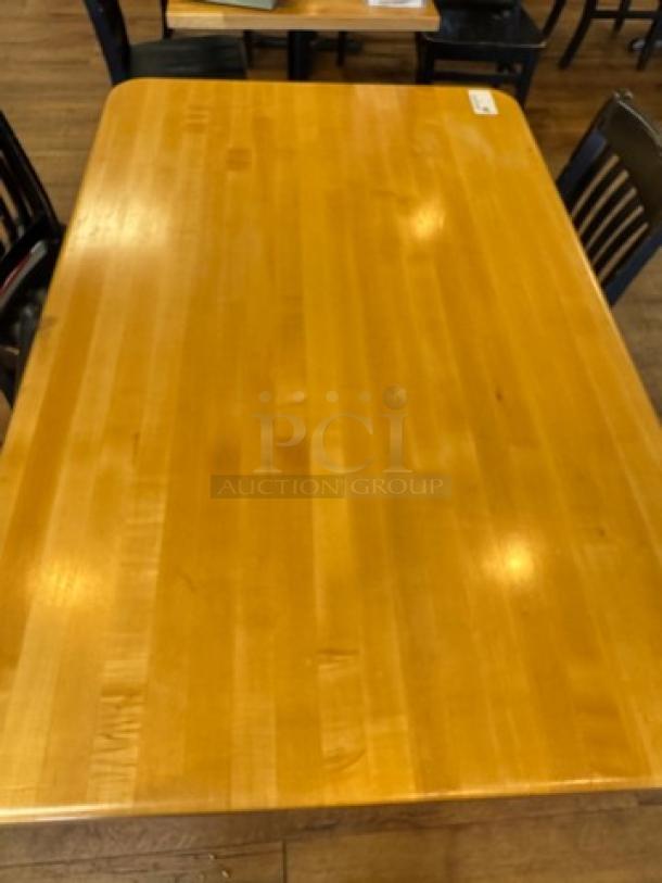 Wooden dining table with a polished surface, rectangular shape, and visible wood grain. Appears in good condition.