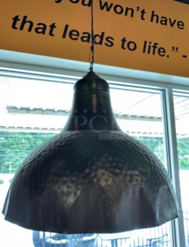 Hammered copper pendant light with a weathered finish, dome shape, and visible ceiling fixture. Part of a set of four.