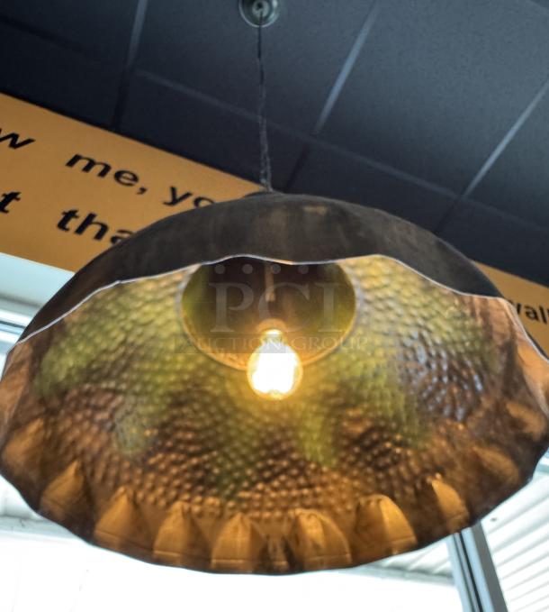 Copper pendant light with a hammered finish, showcasing a glowing bulb, modern design, good condition.