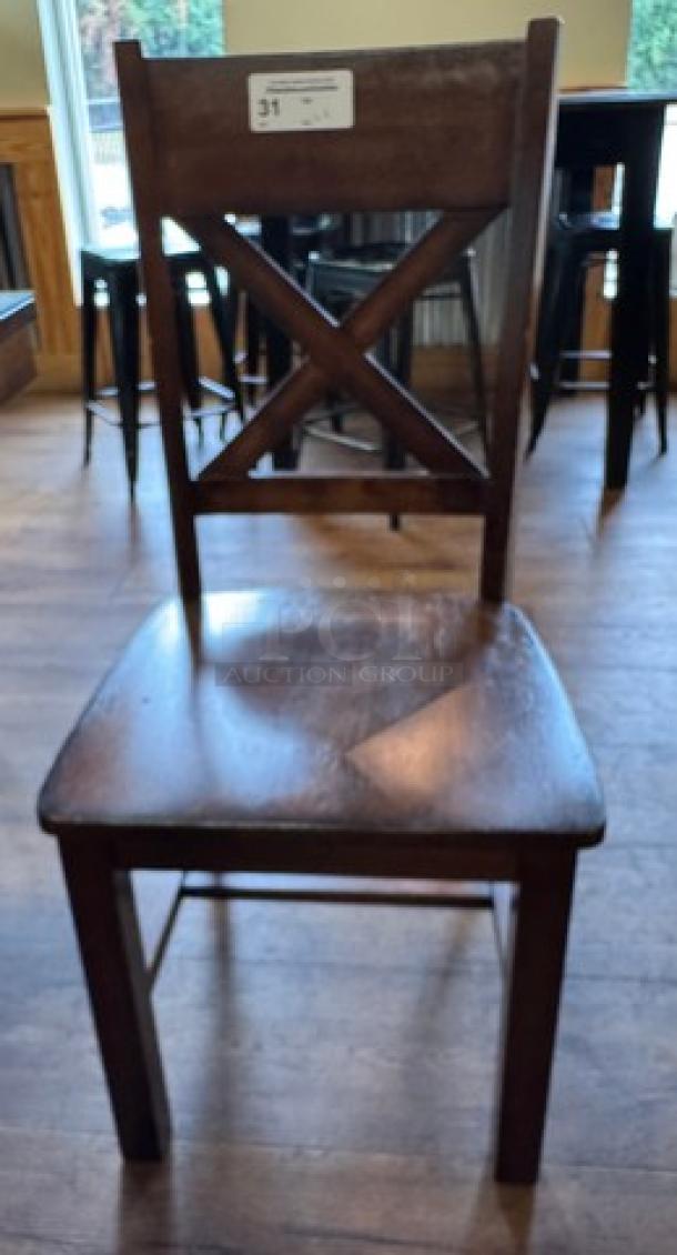Wooden dining chair with X-back design, dark finish, showing moderate wear. Part of a 6-piece set. Auction tag visible.