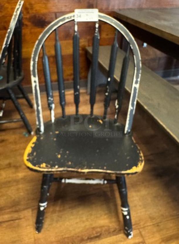 Set of four vintage black dining chairs with spindle backs and distressed finish, showing visible wear. Auction tag label: "34."