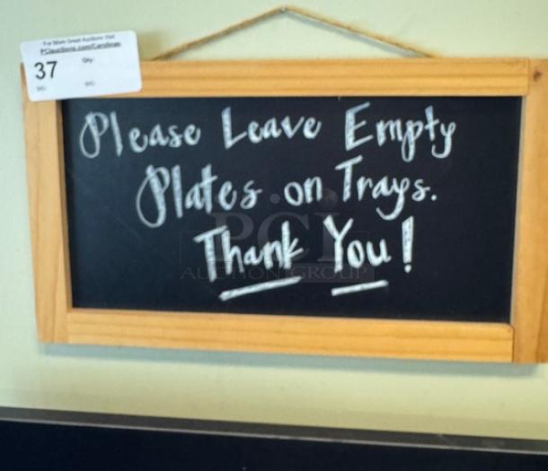 Wooden framed chalkboard sign with white handwritten text: "Please Leave Empty Plates on Trays. Thank You!" Auction tag visible.
