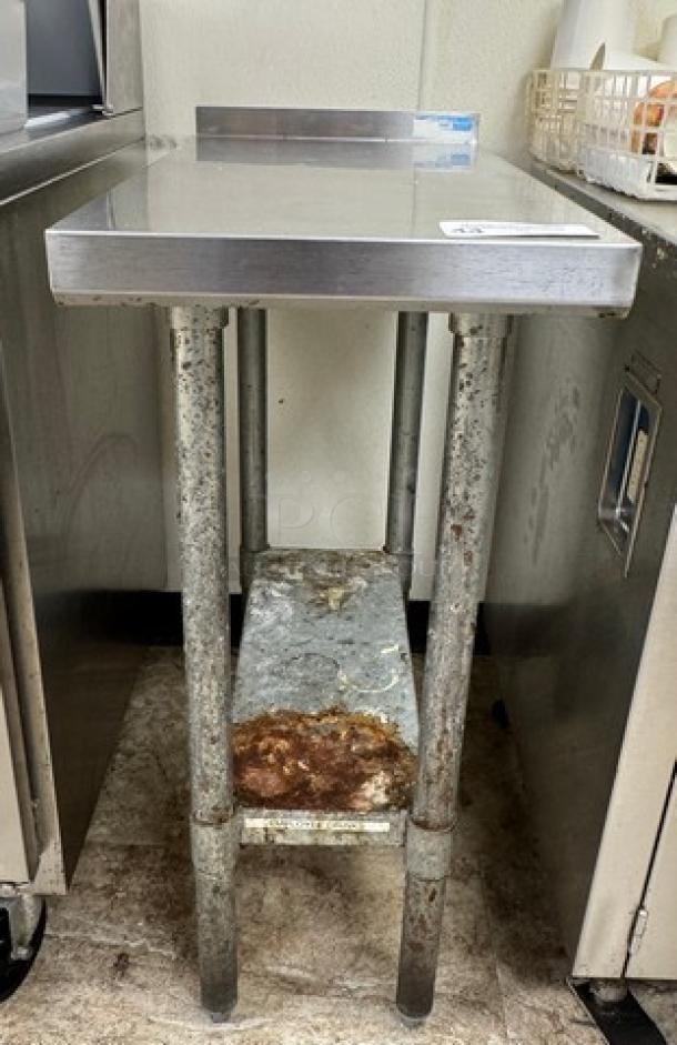 Stainless steel equipment stand with galvanized shelf, rust on the lower shelf, sturdy structure, good for commercial use.