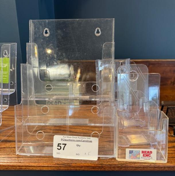 Set of five clear acrylic menu holders, wall-mountable, in good condition. Includes 'Read ENC' label, auction ID: 57.