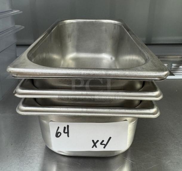 Stainless steel 1/3 x 4 pans, stack of four, in good condition with visible lot number 64.