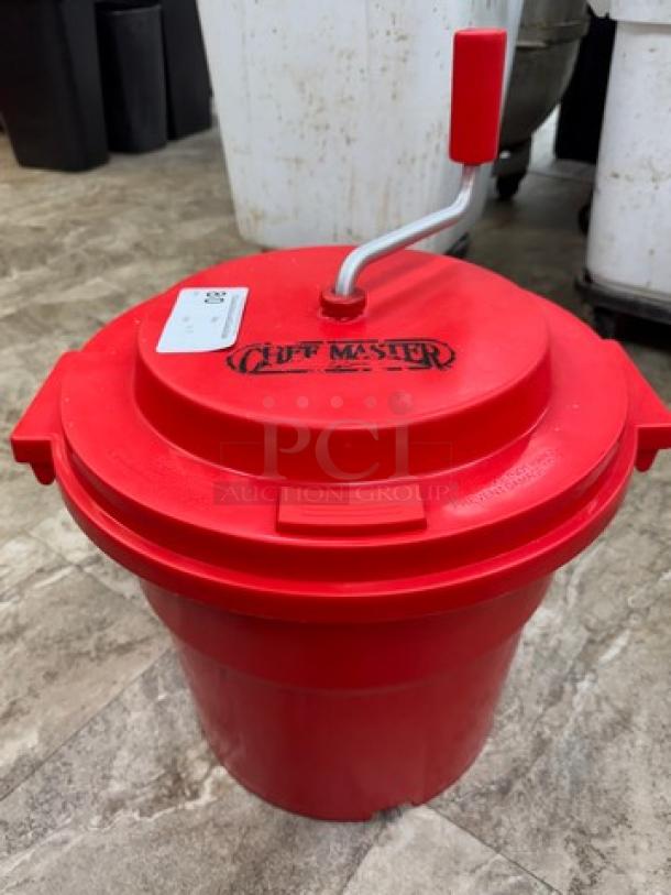 Red Chefmaster spinner/strainer with manual crank handle, branded lid, and label. Used condition on tiled floor.