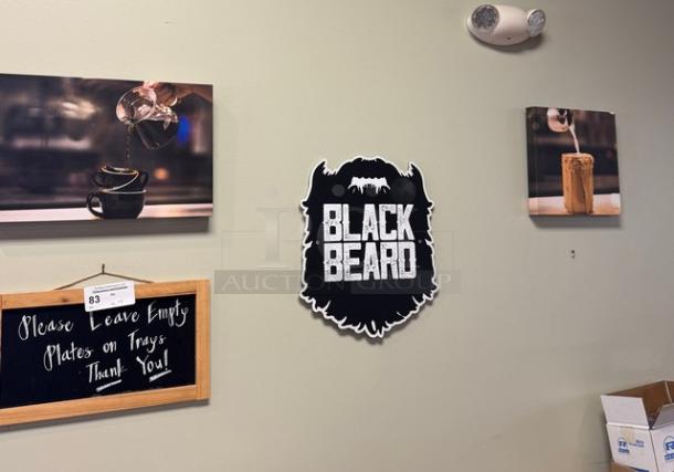 Assorted decorative wall pictures, including a Black Beard sign, coffee-themed art, and a framed notice.