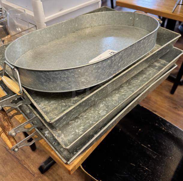 Stack of oval tin trays with wooden handles, slightly weathered, ideal for display or decoration. Auction label with "18".