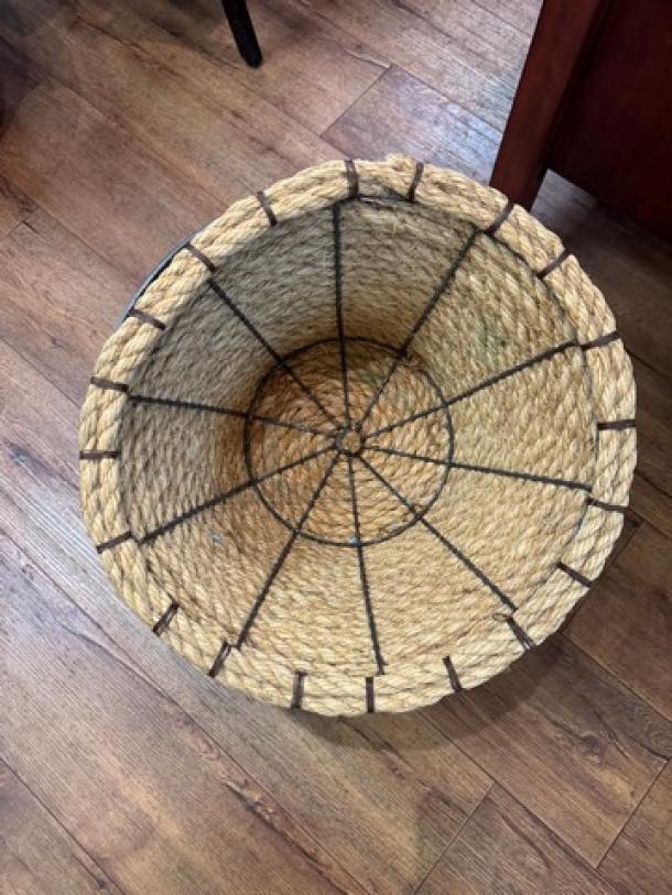 Metal and rope floor display basket with woven natural rope, metal frame, and rustic finish. Appears in good condition.