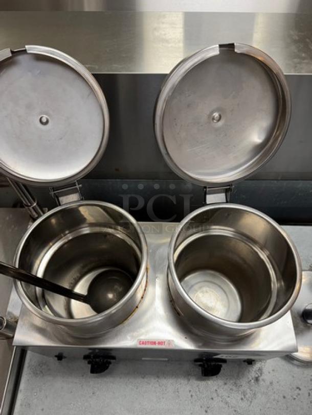 Server chili pot warmer with dual stainless steel compartments, open lids, and a ladle. "Caution Hot" label visible. Used condition.