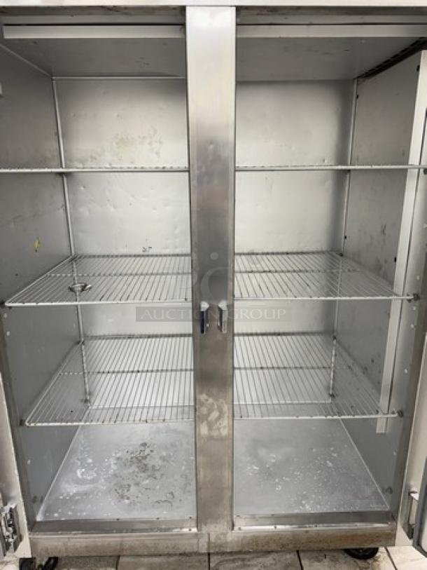 Traulsen 2-door freezer, model G22010, silver, interior shelving, not consistently working, visible wear and stains.