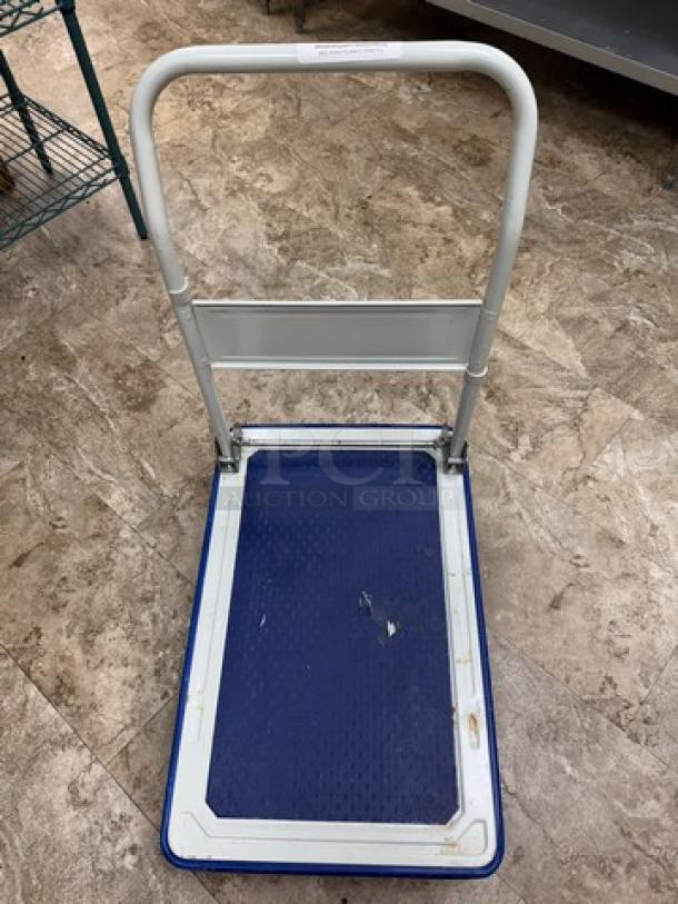 Rolling folding platform cart with blue textured surface and white frame. In good condition, features large handle and wheels.
