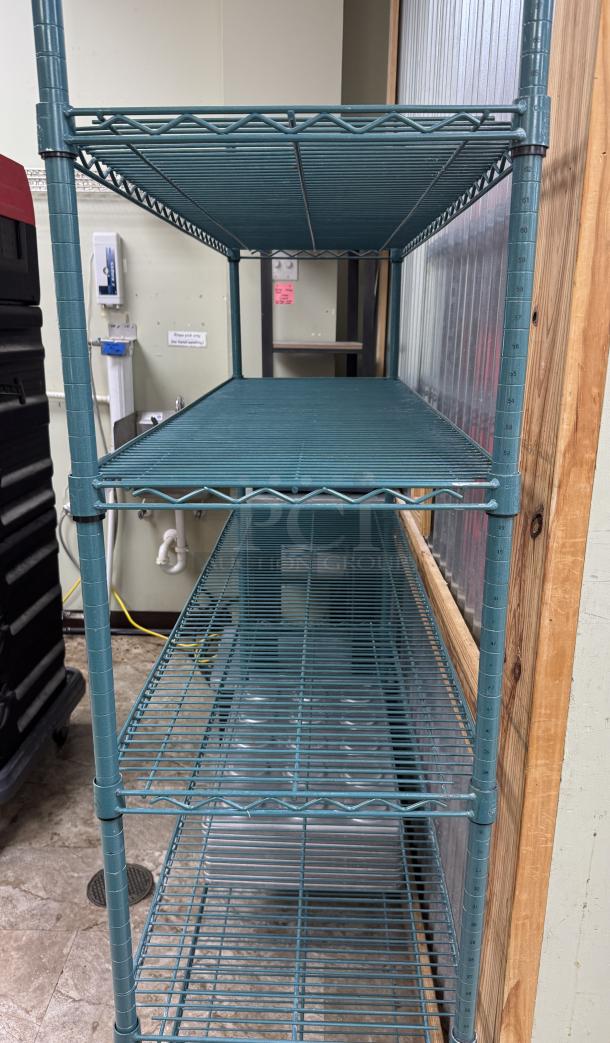 Wire rack with 5 shelves, teal color, metal construction, good condition, adjustable height markers on posts.
