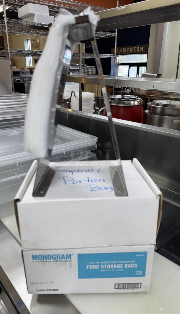 Monogram sealable portion bags with holder on counter, marked "Temporary Portion Bags." Box displays product details.