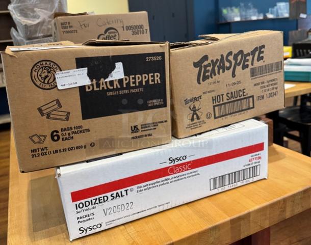 Boxes of Monarch Black Pepper, Texas Pete Hot Sauce, and Sysco Classic Iodized Salt packets, partially open.