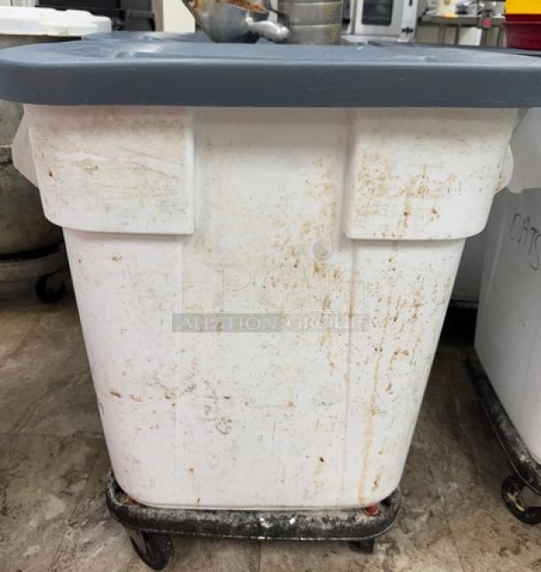 Rubbermaid rolling dry goods storage container, white, with gray lid, on caster wheels. Visible signs of wear and use.